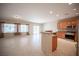 Open-concept kitchen and living area with tile flooring, stainless steel appliances, and breakfast bar at 7726 Coast Jay St, North Las Vegas, NV 89084