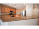 Well-lit kitchen features stainless steel appliances, wood cabinets, and granite countertops at 7726 Coast Jay St, North Las Vegas, NV 89084