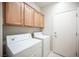 Functional laundry room with washer, dryer, overhead cabinets and tile flooring at 7726 Coast Jay St, North Las Vegas, NV 89084