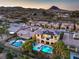 Aerial view of backyard oasis with pool, hot tub, patio, solar panels, desert landscaping, and mountain views at 79 Rezzonico Dr, Henderson, NV 89011