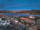 Expansive aerial view showcasing a golf course community with desert landscaping, a lake, and a mountain range at 79 Rezzonico Dr, Henderson, NV 89011