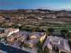 Elevated view of houses in a golf community; view includes lush golf course and distant mountain range at 79 Rezzonico Dr, Henderson, NV 89011