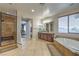 Bright bathroom boasts a walk-in shower, soaking tub, dual sinks, and tiled floors at 79 Rezzonico Dr, Henderson, NV 89011
