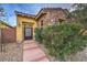 Home's front entrance featuring a stone facade and pathway leading to a secure gate at 79 Rezzonico Dr, Henderson, NV 89011