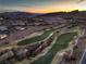 Distant aerial view overlooking the golf course, community, mountains, and colorful sunset in the background at 79 Rezzonico Dr, Henderson, NV 89011