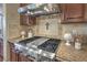 Close up on stainless steel range and custom hood with tile backsplash at 79 Rezzonico Dr, Henderson, NV 89011