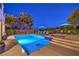 Stunning backyard pool and spa with lounge chairs, illuminated by evening lights, creating a serene ambiance at 79 Rezzonico Dr, Henderson, NV 89011
