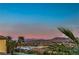 Expansive view of mountains and a lake at sunset seen from lush backyard landscaping at 79 Rezzonico Dr, Henderson, NV 89011