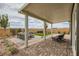 Inviting covered patio with brick flooring, lush landscaping, and comfortable seating for outdoor relaxation at 824 Weston Ridge St, Henderson, NV 89011