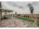 Scenic backyard featuring a covered patio, lush lawn, desert landscaping, and inviting outdoor seating area at 824 Weston Ridge St, Henderson, NV 89011