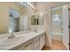 Bathroom featuring dual sinks, white vanity, large mirror, and shower-tub combo at 832 Clear Diamond Ave, Las Vegas, NV 89123