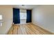 Bedroom featuring wood-look floors, neutral walls, window with blinds and dark blue curtains at 832 Clear Diamond Ave, Las Vegas, NV 89123