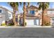 Charming two-story home featuring desert landscaping with mature palm trees and a two-car garage at 832 Clear Diamond Ave, Las Vegas, NV 89123