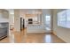 Bright living room with wood floors leading to a kitchen with white cabinets and stainless steel appliances at 832 Clear Diamond Ave, Las Vegas, NV 89123