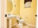 Cozy half bathroom with pedestal sink, toilet, decorative mirror, and bronze fixtures at 8477 Orly Ave, Las Vegas, NV 89143