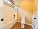 Bright bathroom featuring a tile bathtub and shower combination, paired with a toilet and wood-look vinyl flooring at 8477 Orly Ave, Las Vegas, NV 89143