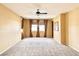 Empty bedroom with neutral carpet, brown curtains, ceiling fan, and ample natural light at 8477 Orly Ave, Las Vegas, NV 89143