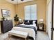 Stylish bedroom features a bed with elegant furnishings, a dark dresser, and soft lighting at 8477 Orly Ave, Las Vegas, NV 89143