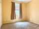 Empty bedroom with neutral carpet and trim, brown curtains, and natural light at 8477 Orly Ave, Las Vegas, NV 89143