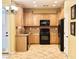 Well-lit kitchen featuring matching appliances, wooden cabinets, and tile flooring at 8477 Orly Ave, Las Vegas, NV 89143