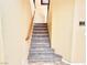 Carpeted staircase with wooden handrail, neutral walls and a decorative key holder on the wall at 8477 Orly Ave, Las Vegas, NV 89143
