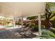 Covered backyard patio offers a tranquil outdoor space with lush landscaping and shade at 8743 Mount Mira Loma Ave, Las Vegas, NV 89178
