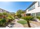 Beautifully landscaped backyard featuring a decorative stone fire pit and covered patio at 8743 Mount Mira Loma Ave, Las Vegas, NV 89178