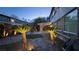 Backyard landscaped with stone fire pit and covered patio, enhanced by outdoor lighting at 8743 Mount Mira Loma Ave, Las Vegas, NV 89178