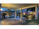 Evening view of the landscaped backyard, featuring a covered patio and stone fire pit at 8743 Mount Mira Loma Ave, Las Vegas, NV 89178