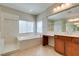 Bright bathroom features a large soaking tub, glass block partition, and double sink vanity at 8743 Mount Mira Loma Ave, Las Vegas, NV 89178