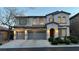 Well-maintained two-story home with a three-car garage, front yard shrubs, and warm exterior lighting at 8743 Mount Mira Loma Ave, Las Vegas, NV 89178