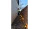 Exterior side yard walkway illuminated by garden lights for nighttime ambiance at 8743 Mount Mira Loma Ave, Las Vegas, NV 89178