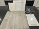 Selections of bath fixtures, cabinets, and flooring feature a chrome faucet, white cabinets, and warm gray vinyl plank at 9141 Eagle Ford St, Las Vegas, NV 89113