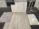 This design sample showcases sleek stainless steel fixtures, white cabinets, and a luxurious warm gray flooring choice at 9141 Eagle Ford St, Las Vegas, NV 89113