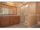 Bathroom featuring a glass-enclosed shower, wood cabinets, and tiled floors at 9323 W Rochelle Ave, Las Vegas, NV 89147