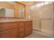 Bathroom features a shower with glass doors, granite countertops, and classic wood cabinets at 9323 W Rochelle Ave, Las Vegas, NV 89147