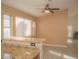 Bright dining area features a ceiling fan, tiled flooring, and a breakfast bar with granite countertops at 9323 W Rochelle Ave, Las Vegas, NV 89147