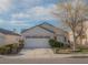 Lovely single-story home featuring a spacious driveway, two-car garage, and beautiful tree at 9323 W Rochelle Ave, Las Vegas, NV 89147