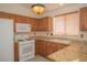 Cozy kitchen with wood cabinets, granite countertops, tile backsplash and white appliances at 9323 W Rochelle Ave, Las Vegas, NV 89147