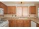 Updated kitchen featuring granite countertops, tile backsplash, wooden cabinets, and modern white appliances at 9323 W Rochelle Ave, Las Vegas, NV 89147