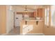 Open kitchen with wooden cabinets, a breakfast bar and white appliances at 9323 W Rochelle Ave, Las Vegas, NV 89147