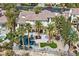 Aerial view of a large estate featuring a pool, mature palm trees and a well-manicured lawn at 104 N Royal Ascot Dr, Las Vegas, NV 89144