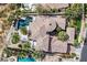Drone's-eye view of a well manicured private backyard with pool, lounge area and palm trees at 104 N Royal Ascot Dr, Las Vegas, NV 89144