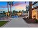 The backyard features a pool, lush landscaping, a patio, and multiple seating areas at twilight at 104 N Royal Ascot Dr, Las Vegas, NV 89144