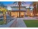 A spacious backyard features a swimming pool, lush landscaping, and a covered patio for outdoor living at 104 N Royal Ascot Dr, Las Vegas, NV 89144