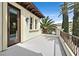 Outdoor balcony with a glass door, white stucco walls, and palm tree views at 104 N Royal Ascot Dr, Las Vegas, NV 89144