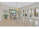 Bright dining room featuring travertine floors, a glass dining table, and sliding glass doors to the outdoor living area at 104 N Royal Ascot Dr, Las Vegas, NV 89144