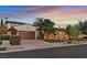 Beautiful home exterior showcasing the garage, driveway, manicured landscaping, and stone accents at dusk at 104 N Royal Ascot Dr, Las Vegas, NV 89144
