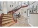 Elegant foyer featuring a curved staircase with ornate iron railings and marble floors with decorative inlays at 104 N Royal Ascot Dr, Las Vegas, NV 89144