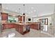 Spacious kitchen featuring dark wood cabinets, a large island, granite countertops, and views into an adjacent living space at 104 N Royal Ascot Dr, Las Vegas, NV 89144